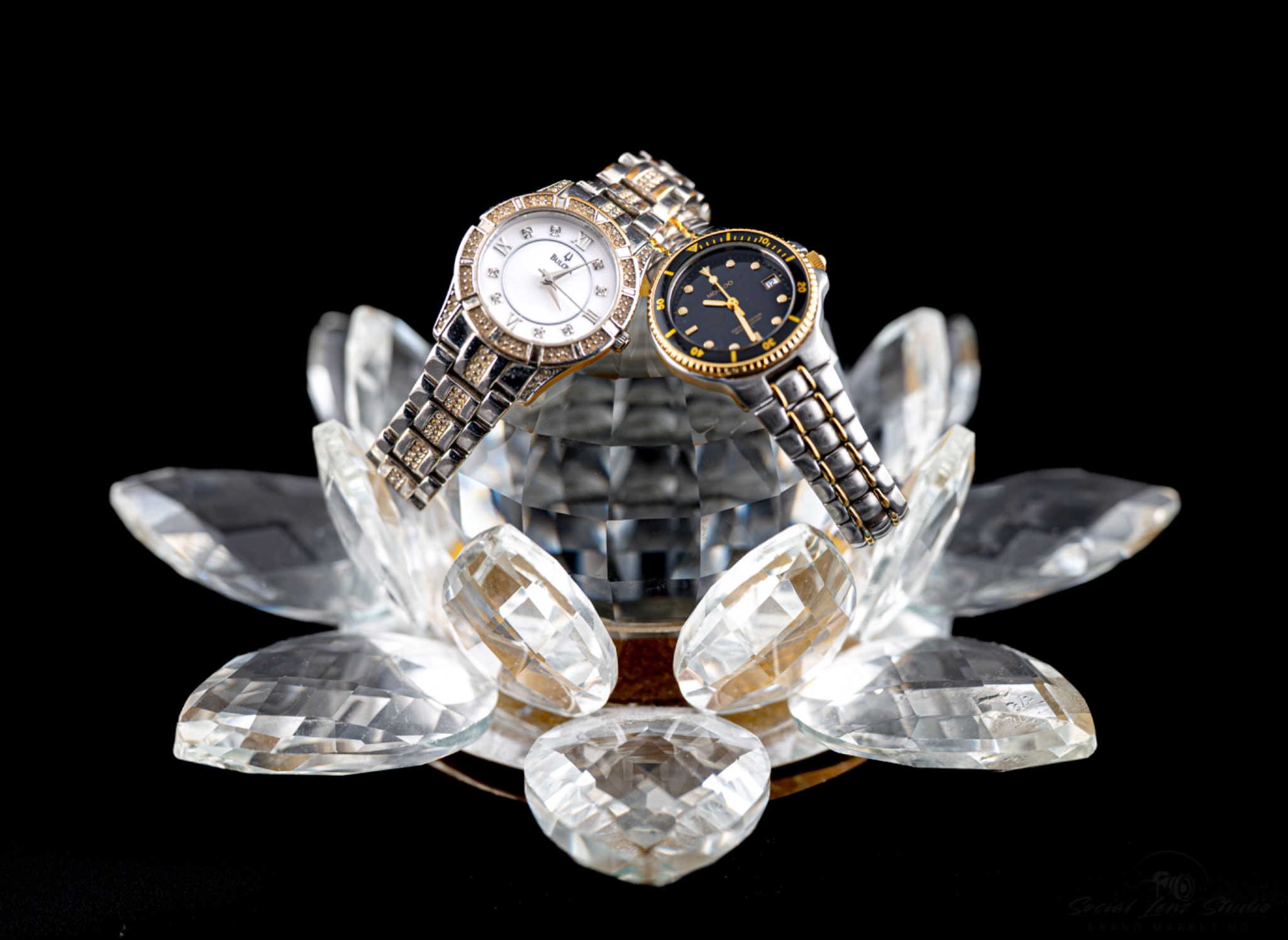 Studio product photograph of two watches on crystal